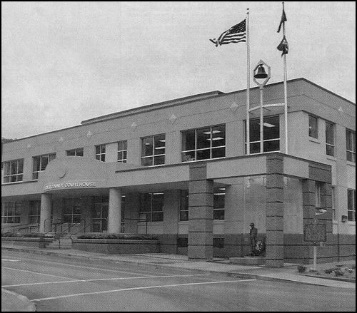 Earlier this month {October} the newly remodeled 1960's courthouse was rededicated. The remodeling moved the jail from the top floor of the courthouse to the lower floor, which is on street level at the rear of the building, and traded the shiny blue and beigh panels for a tan masonary-like exterior. A statue honoring veterans of all wars was moved from the east to the west end of the front of the building. The bell in the front is the same one which called jurors to court in the 1898 courthouse.