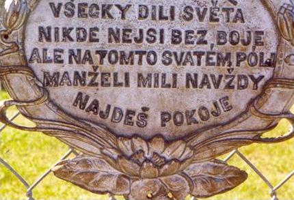 Ornate cast metal plaque with inscription on cemetery gate